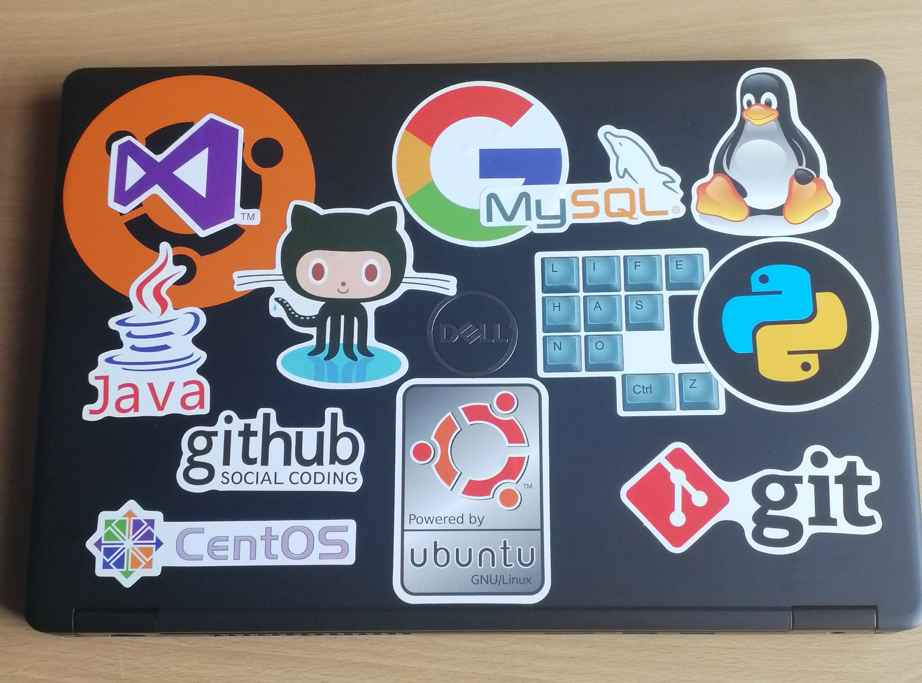 A dell laptop personalised with various github stickers
